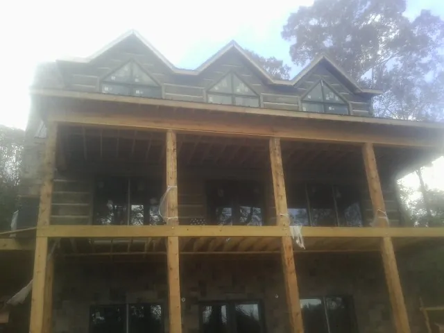 Dormers and porch framing on a large log home under construction — Roof Coating work by our crew in Rimersburg