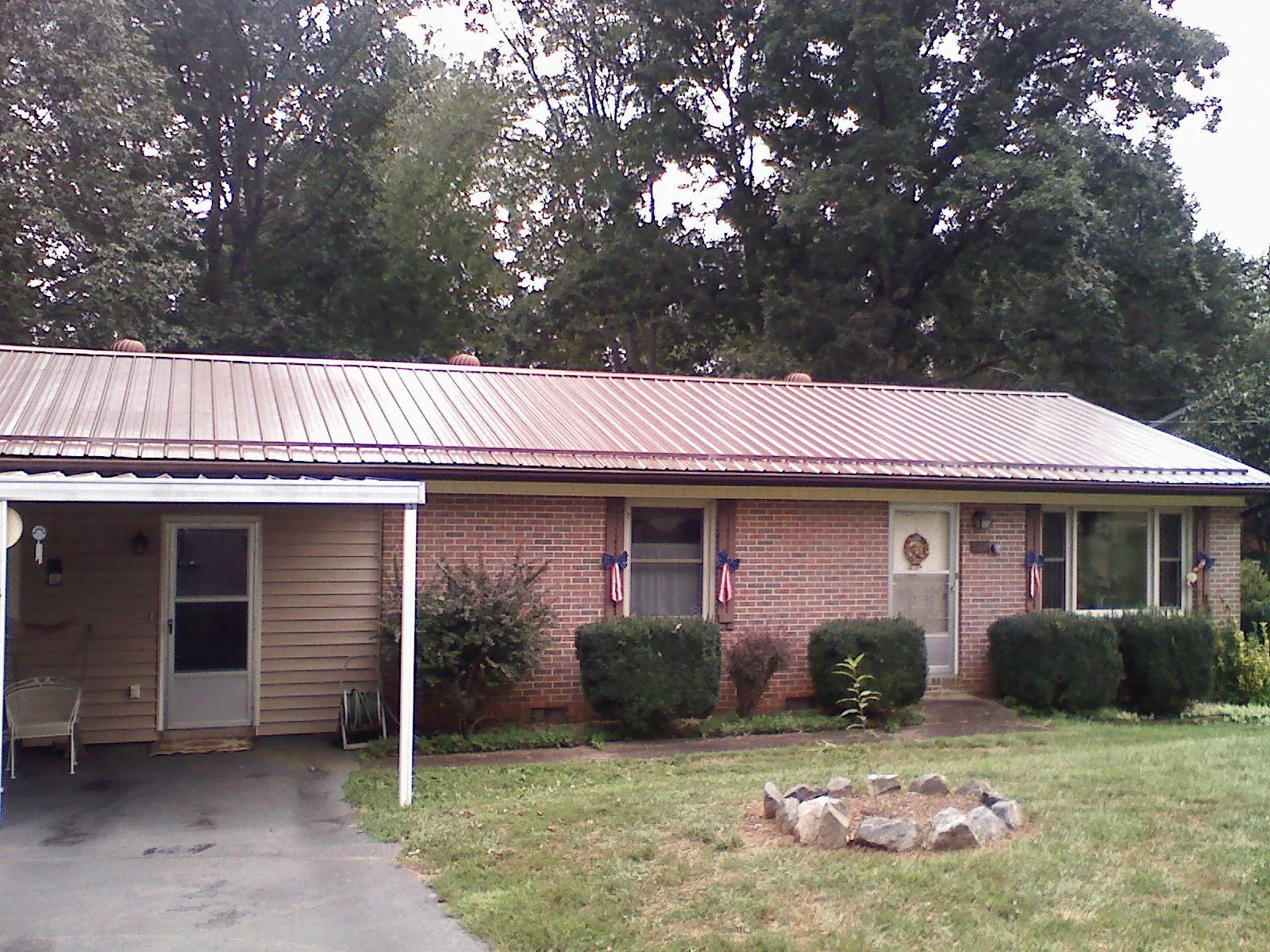 Bronze metal roof and carport on a brick ranch home — Roof Repair work by our crew in Rimersburg